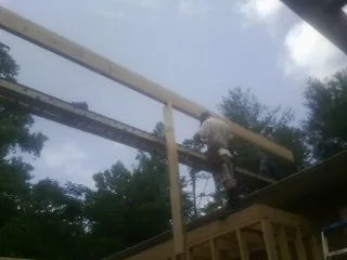 Carpenter setting a ridge beam over a new addition frame — Ice Dam Removal by Roofing Brothers in Talmo