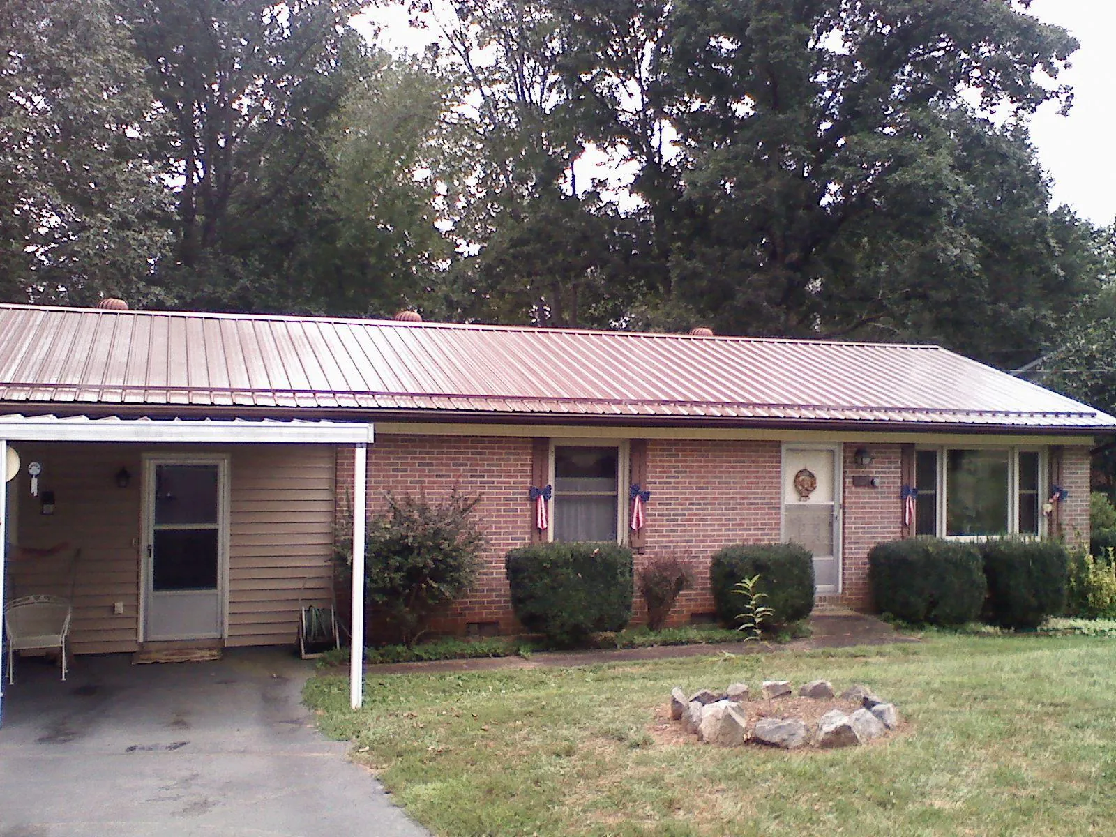 Bronze metal roof and carport on a brick ranch home — Roof Repair work by our crew in Talmo